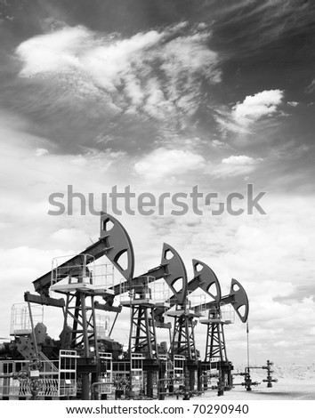 Pump jacks on a oil field. Black and white photo