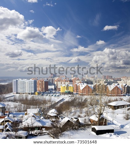 Cityscape of old and new district. Winter town/ White clouds on a blue sky