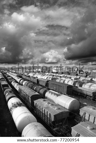 Railroad cars on a railway station. Cargo transportation. Storm clouds above train. Black and white photo