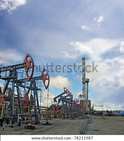Oil and gas industry. Work of oil pump jack and rig on a oil field.