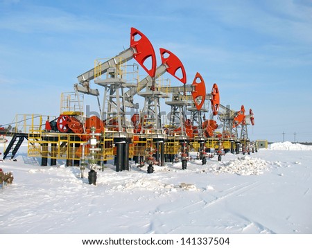 Oil and gas industry. Work of oil pump jack on a oil field. Winter extraction of oil. Oil industry of West Siberia
