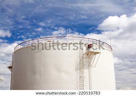 Oil reservoir and blue sky with clouds. Oil industry and gas refinery plant. Industrial scene of oil field