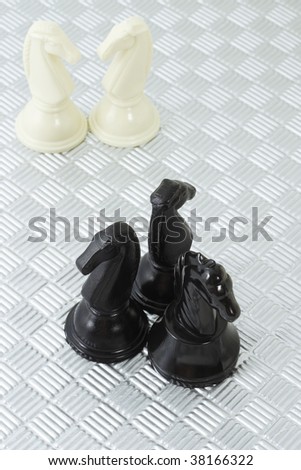 Black and white knights on metallic background