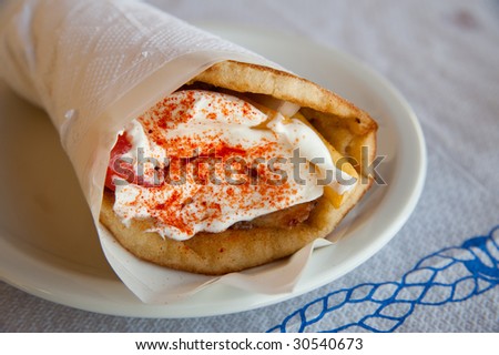 Gyros Pita is traditional Greek fast food. It is a bit kebab style, but not so spicy. It is made of pita bread, pork meat, french fries, tomatoes, onion and yogurt style sauce.