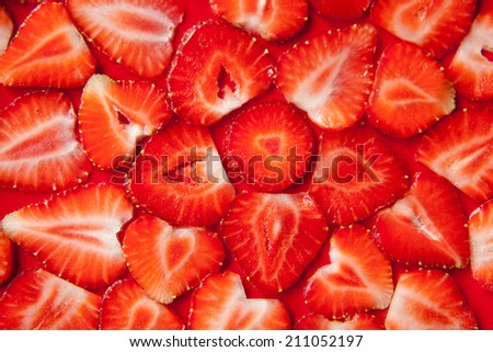 Fresh strawberry slices on red background. All created as a flower pattern. Fresh summer wallpaper or background, healthy life and food.