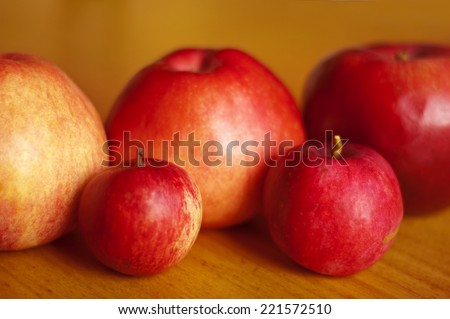 Red apples presented on wooden board.