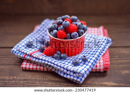 Red cup with wild fruits like blueberry and raspberry. All on the blue and red background.all and background berries berry blue blueberry board braided cake cup dessert  forest fruit l  red sweets
