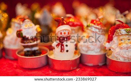 Christmas tealights with Santa Clause and snowman statuettes on the top selling during Christmas MArket. Christmas time, postcard, background.