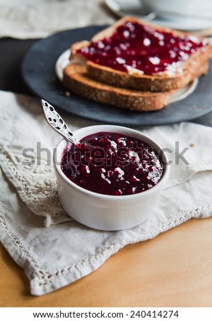 Wild fruit jam on toast homemade jam with fresh fruits like strawberry, bramble, raspberry, blackberry, blueberry, red currant from garden. Fruit jam on toasted slice of whole grain bread.