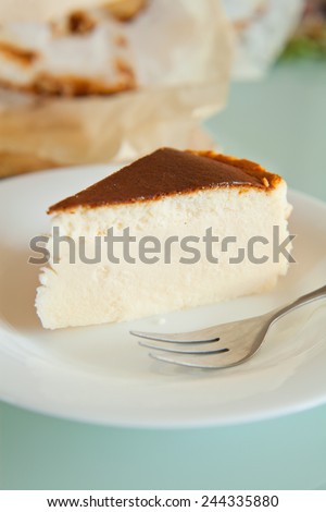 Piece of vanilla cheesecake with crashed biscuits on the top. Cheesecake was prepared with flour, white cheese, white sugar, vanilla sugar, eggs and butter. Presented on white plate.