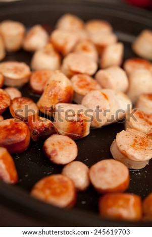 Small sausages cut into pieces frying on frying pan. Food, meat, macro perspective, home-made meal, nobody.