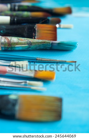 Different size paintbrushes presented on the blue background. Macro perspective, nobody, art  tools.