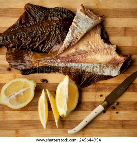 Pieces of fresh fish. Fish and lemon on a wooden breadboard with rosemary twig. Macro, fresh food, natural ingredients. Helpful on a diet. Healthy food. White fish fillets