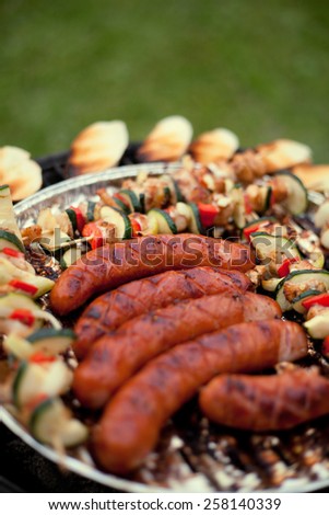 Grill sausages with chicken shashliks prepared with cucumber, onion, red pepper cut into pieces, slices, dices. Barbecue. Fresh vegetables. Dinner in a garden. broache, grill. Macro perspective
