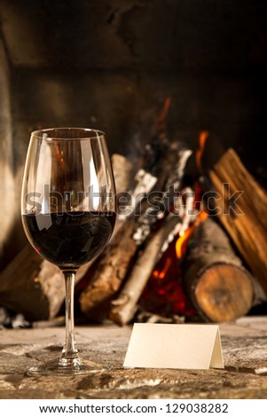 A cups of wine with fire on the background, romantic meal. Love. Write your own message.