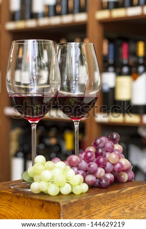 Cups of red wine and grapes, background with bottles of wine, winery. Mendoza Argentina. culture tradition.