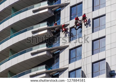 DUBAI, UAE - FEBRUARY 03: Specialized firm cleans up the facade of the skyscraper on February 03, 2013 in Dubai, UAE. Service is competitive, firms provide also monitoring building\'s condition and damage detection.