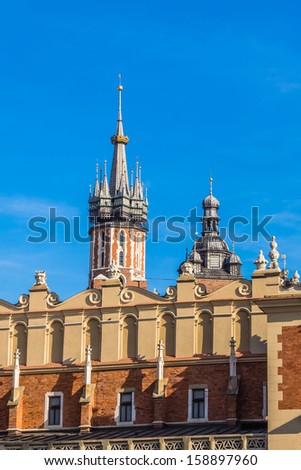 Facade of the Sukiennice (historical clothing marketplace) on the Main Market Square in Krakow, Poland. In the background towers of St. Mary\'s Church.