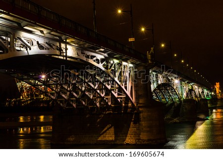 WARSAW, POLAND - DECEMBER 29: Night view of Poniatowski bridge on December 29, 2013 with National Stadium in the background. The 506m long steel bridge, designed and constructed in the years 1904-1914