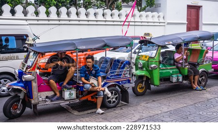 BANGKOK, THAILAND - OCTOBER 31, 2014: Motor bike rickshaw drivers wait for clients at the entrance to the Temple of the Reclining Buddha. Motor bike rickshaws replaced traditional bike based model.