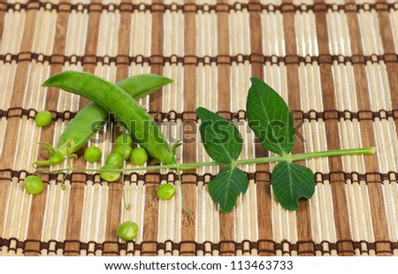 Fresh peas pods with tendril on a straw mat