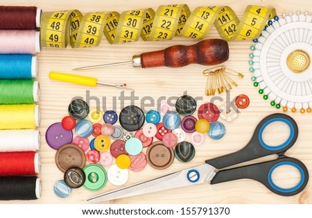 Various sewing accessories with tape measure on a wooden surface