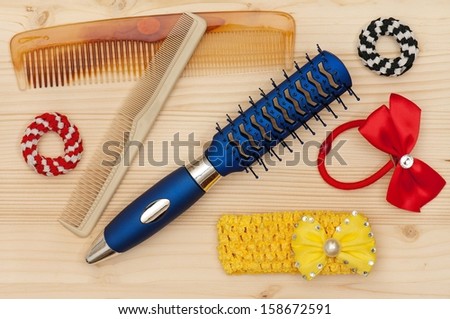 New hairbrush with accessories over wooden surface