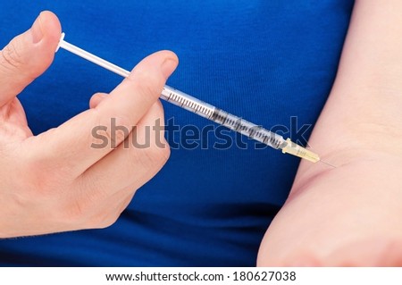 The woman does herself an insulin injection close-up
