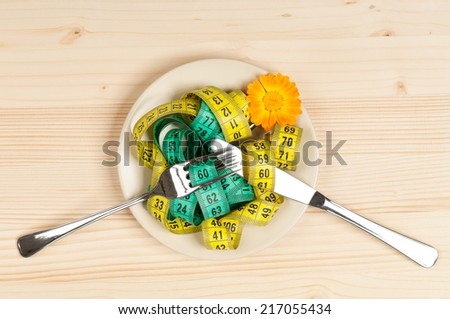 Colorful tape measures in a saucer on a wooden surface concept