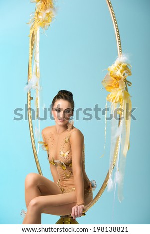 Plastic beautiful girl gymnast on acrobatic circus ring in flesh-colored suit