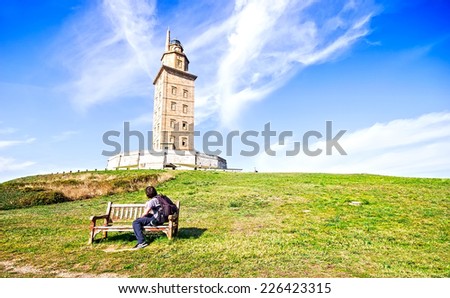 A man sitting on a bench looking The Hercules tower in La Coruna, Galicia, Spain, UNESCO