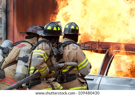 Firemen extinguishing a car fire