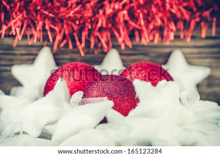 Christmas Background Made of Red Balls and White Snowy Stars on a Vintage Wooden Background