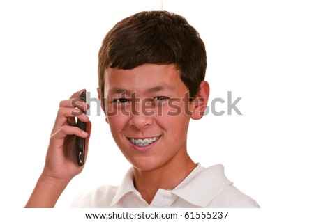 Teenage boy with brown hair and eyes in a white shirt using his cellphone to talk and text.