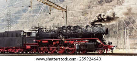 historic steam train in the snow in the mountains of Switzerland