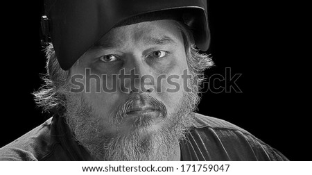 Black and white image of a welder with beard