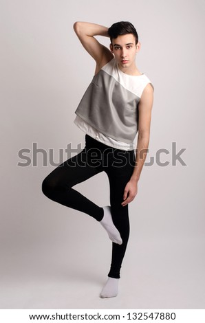 Pose like a perfect model. Young male dancer posing in studio, artistic movement.