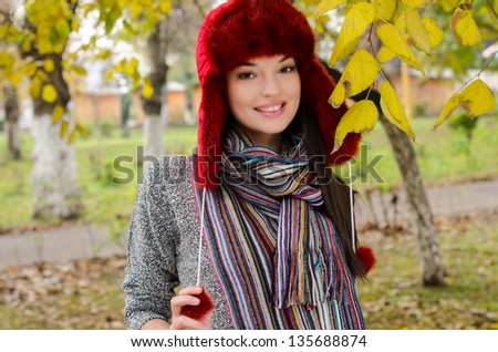 Sexy young brunette girl in autumn scene. Young attractive woman walking in the park in autumn.