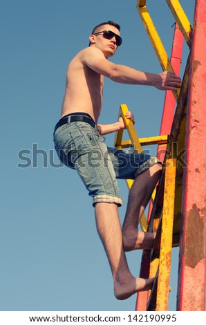 Young man climbing stairs to the sky