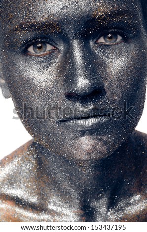Beautiful face of a woman covered in glitter Close up of a woman\'s face covered in silver and blue glitter