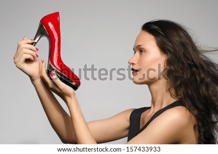 Woman in love with her high heel shoes. Beautiful girl admiring her red sexy stiletto shoes.
