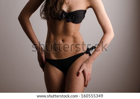 Woman in swimsuit with perfect abs, fit body