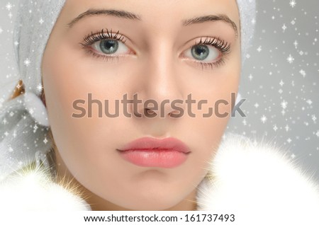 Close up portrait on beautiful woman face. Snow white. Snowflakes background. Girl with big blue eyes.