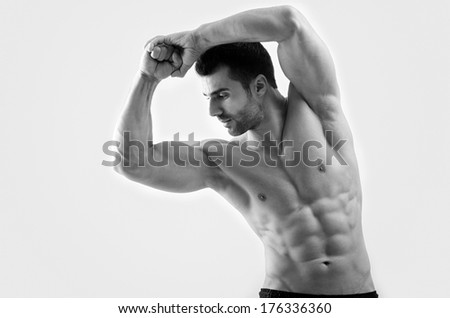 Strong bodybuilder man with perfect abs, shoulders,biceps, triceps and chest flexing his muscles