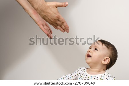 Father reaching to his beautiful baby. Newborn happy to see his father trying to protect and showing him love