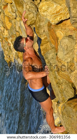 Strong bodybuilder with six pack.Fitness trainer with perfect abs, shoulders,biceps, triceps,chest, flexing his muscles on the beach, training in vacation, climbing on a mountain