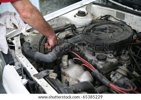 Man checking the oil in a car motor