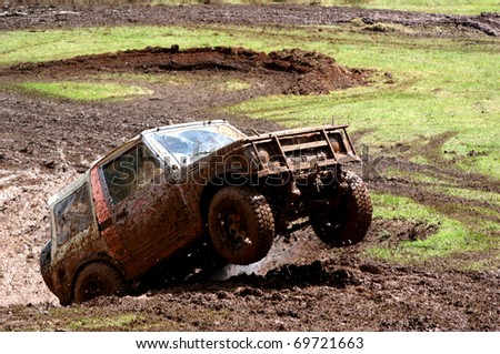 Four wheel drive vehicle bouncing it\'s way out of a hole