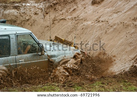 Mud and water splashing as a four wheel drive vehicle goes through a mud hole