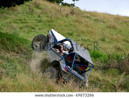 Off road vehicle bouncing as it goes up a steep grass hill